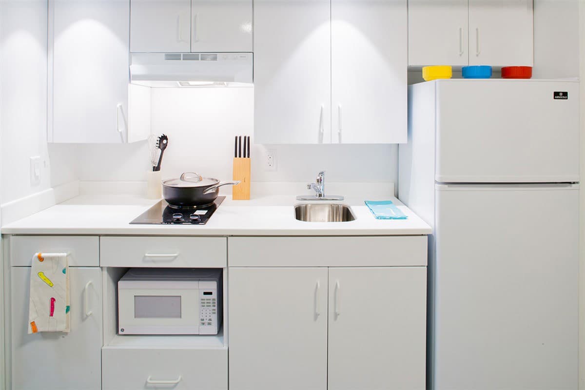 Kitchens in suites include a sink, ample cabinets, large refrigerators, a two-burner cooktop, and a microwave oven.